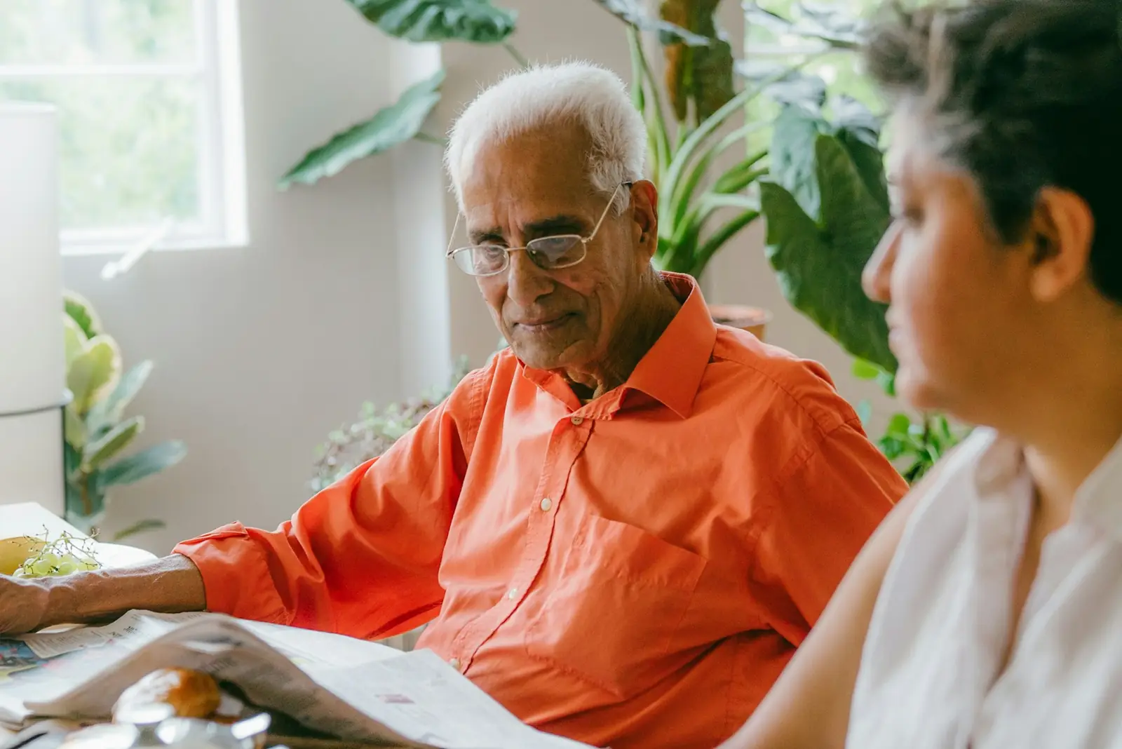Un pensionato legge dei documenti con una consulente